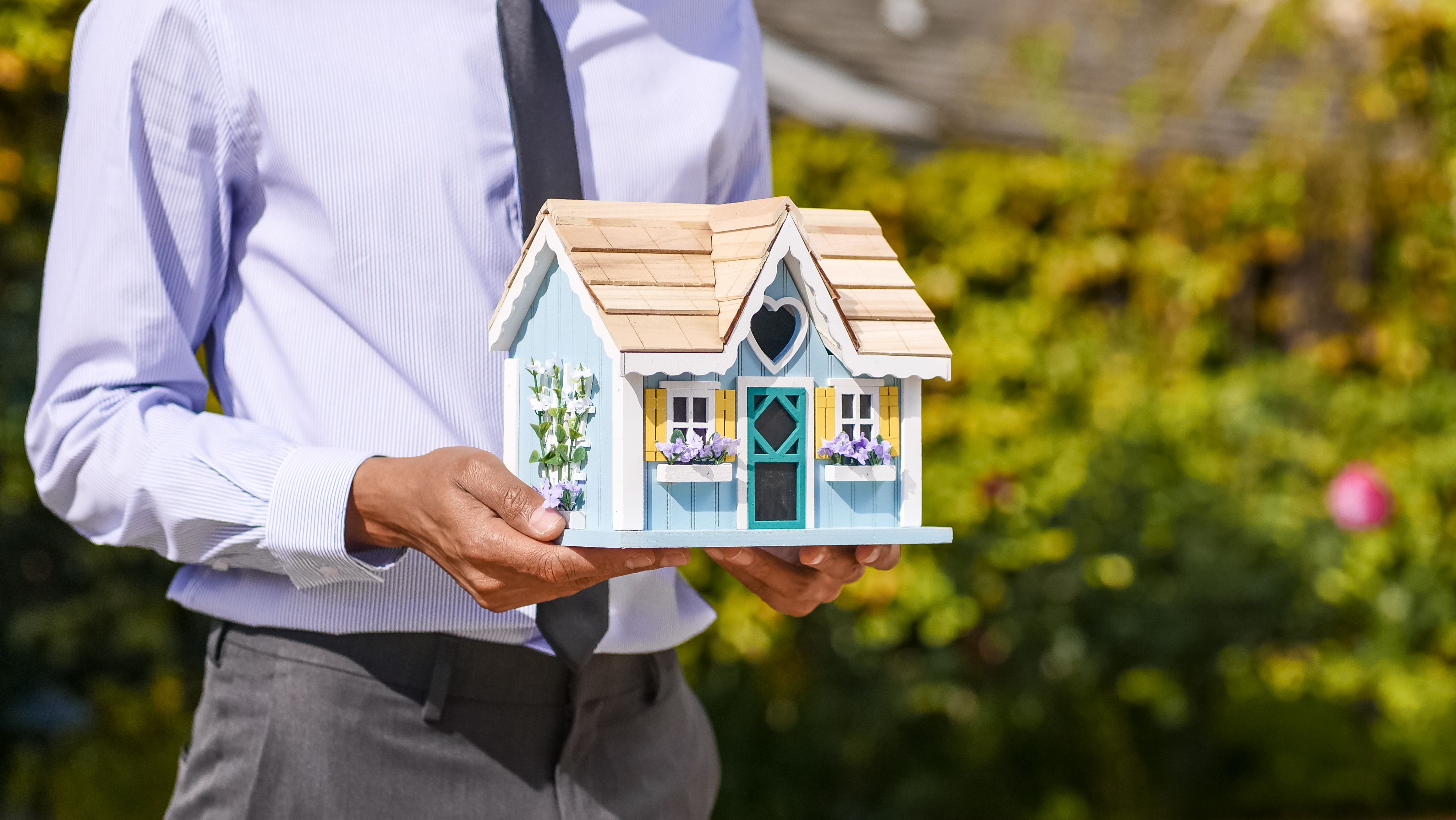 An adviser holding a model home