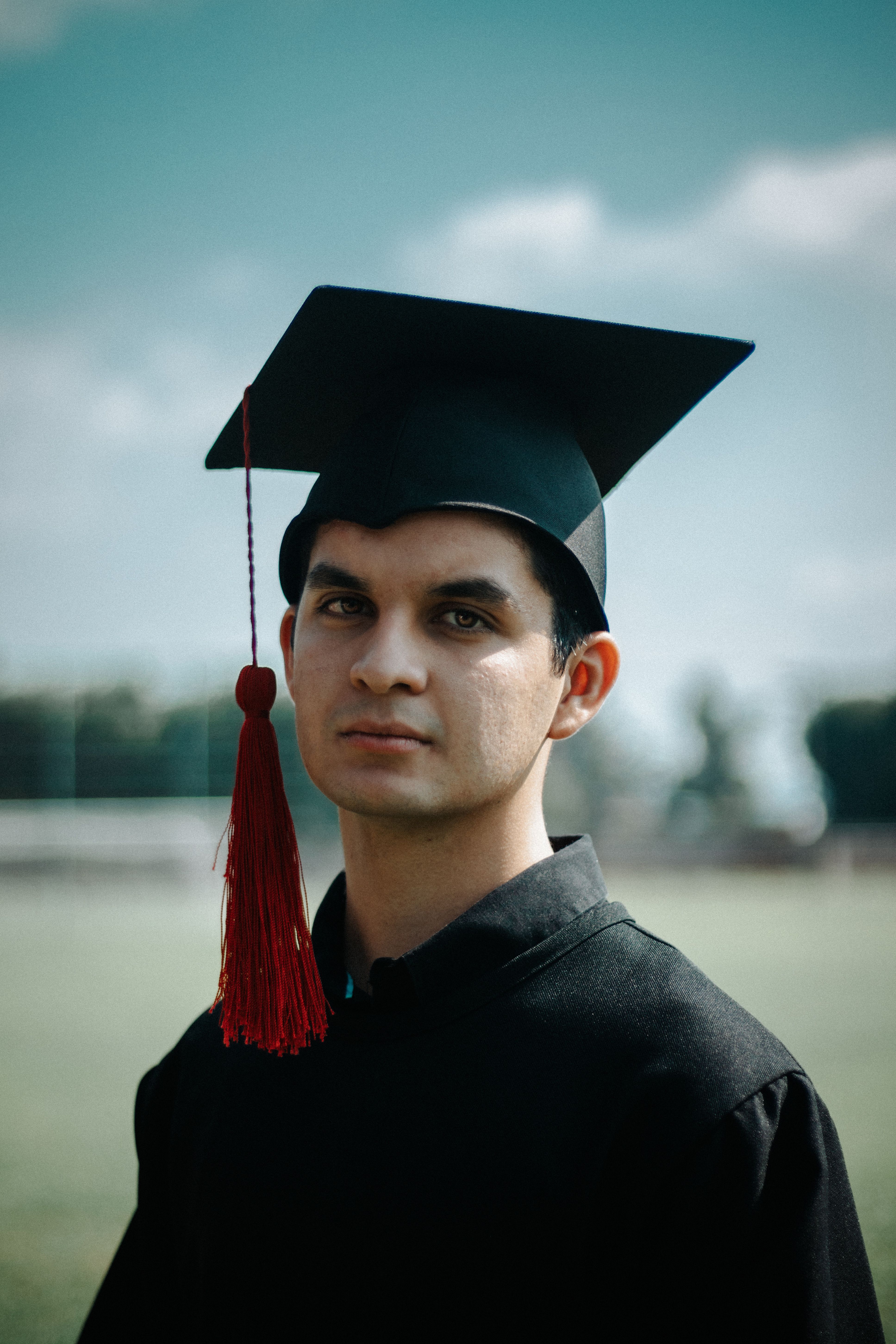 A smiling graduate holding a diploma
